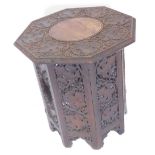 An Indian carved hardwood occasional table, the octagonal top decorated with grapes and vines, on