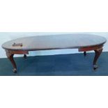 An early 20thC mahogany extending dining table, the oval top on cabriole legs, ceramic castors,