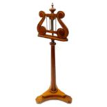 A mahogany music stand in George IV style, the lyre shaped rest with brass rails, on adjustable part