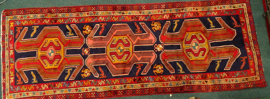 An Azari runner, with three shaped medallions on a blue ground, decorated with animals and birds,