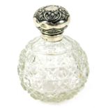 An Edwardian silver topped scent bottle, with heart design repousse ecorated top, faceted glass