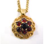 A 9ct gold garnet pendant, with circular floral pendant head, set with seven garnets, in claw