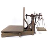 A set of 19thC rustic cast iron and pine weighing scales, 70cm W.