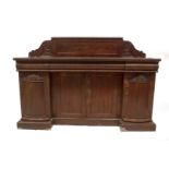 A William IV mahogany breakfront sideboard, with flame panelled back with carved scroll ends,