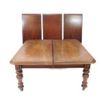 A Victorian mahogany pull out dining table, with double thumb molded top channeled frieze and turned