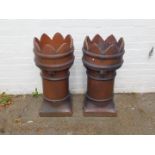 A pair of Victorian terracotta chimney pots, of crown cylindrical form, raised on a square base,