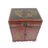 A 20thC Chinese red lacquer table cabinet, decorated with figures at a table, dragons and birds, the