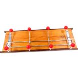 A pine oak and metal atomic coat rack, with eight red balls, 15,5cm H, 49.5cm W.