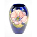 A William Moorcroft baluster vase, blue ground and tube lined with anemones, impressed mark to