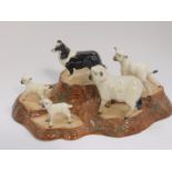 A Beswick pottery tree stump stand, together with a collie dog, sheep and three lambs.