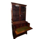 A George III mahogany secretaire bookcase, the outswept pediment with dentil moulding, over a pair