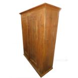 A pine double wardrobe, the outswept pediment over a pair of doors, raised on a bracket foot base,