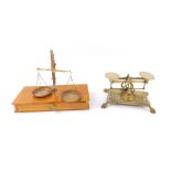 A pair of Victorian brass scales, raised on a rectangular base embossed with foliate decoration,