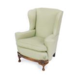 A Georgian style oak framed wingback armchair, upholstered in green herringbone fabric, raised on