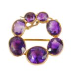 An amethyst circular brooch, set with varying sized amethyst stones, mainly oval cut, the largest