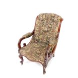 A Victorian mahogany scroll back nursing chair, upholstered in patterned fabric with flowers and