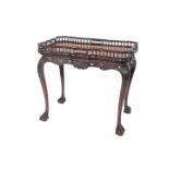 A George III serpentine mahogany silver table, with a galleried top, over a foliate carved apron and