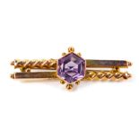 An Edwardian 9ct gold and amethyst bar brooch, the hexagonal cut amethyst in a double square and