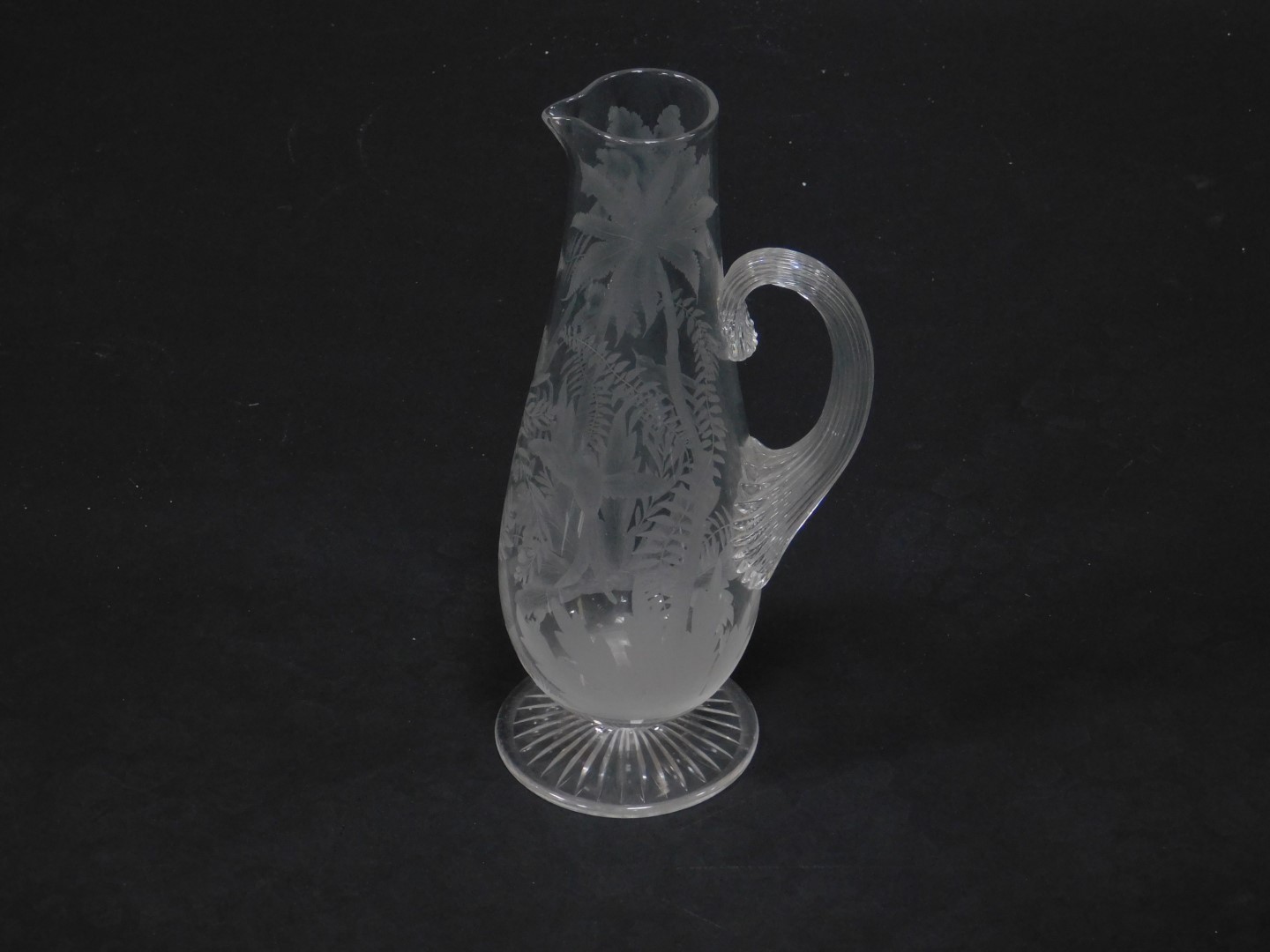 A late 19thC Stourbridge glass jug, of baluster form with a fluted handle, engraved with