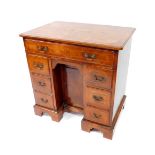 A George II walnut and feather crossbanded kneehole desk, with a quarter veneered top, over one long