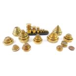 A set of seven Victor cylindrical brass weights, 1/4oz - 1lb, in an oblong cast iron stand, and