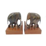 A pair of ebony carved elephant bookends, raised on hardwood block bases, 21cm H, 17.5cm D.