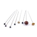 A collection of vintage hat pins, including five small and one large ball knop, one for the