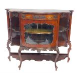 A Victorian serpentine fronted display cabinet, with a foliate carved drawer above a shaped glass