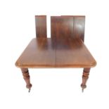 A Victorian mahogany pull out dining table, with double moulded top and turned and tulip carved legs