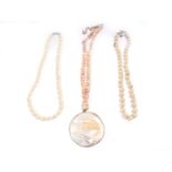A string of pink freshwater pearls, with a oyster shell pendant, and two further strings of