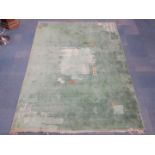 An Art Deco green ground rug, with geometrical and wave decoration, 370cm x 273cm.