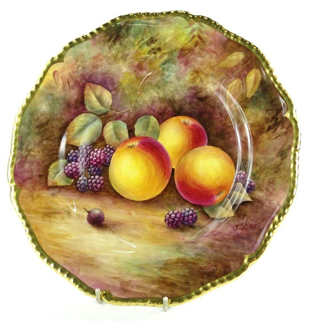 A Royal Worcester porcelain plate, decorated with fruit by J Skerrett, within gilt borders,