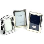 Two modern silver rectangular photograph frames, and a silver plated frame with shaped bands, the