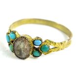 A gilt metal dress ring, set with turquoise shoulders and central white paste stone, with V shaped