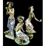 Three Lladro porcelain figures of exotic ladies, each wearing a sarong type skirt and with flowering