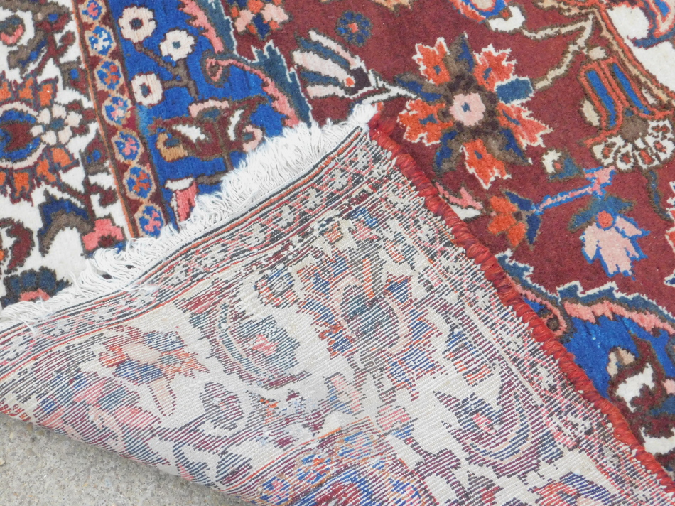 A Persian carpet, with an all over design of flowers, on a red ground with multiple borders, 314cm x - Image 3 of 3