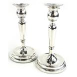 A pair of Edwardian silver candlesticks, each with a turned knop and plain sconce, loaded, Chester