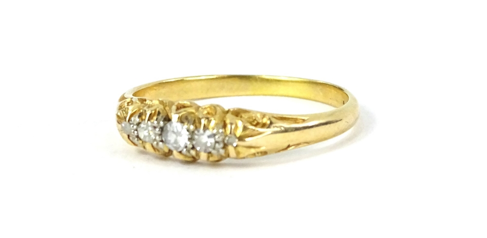 An 18ct gold diamond set gypsy ring, with five tiny diamonds, each in claw setting, with pierced
