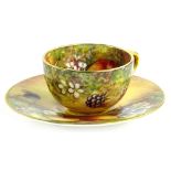 A Royal Worcester porcelain miniature cup and saucer, painted with fruit by J Skerrett, printed
