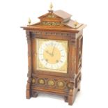 A late 19thC German mantel clock, in oak case, with brass mounts, the shaped pediment applied with