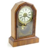 A late 19thC American mantel clock, the paper dial with Roman numerals, the arched glazed door