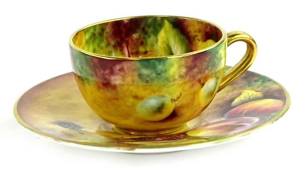 A Royal Worcester porcelain cup and saucer, painted with fruit by T Knott, printed mark in black