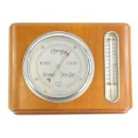 A Federal brand aneroid barometer, with silvered dial and thermometer in a walnut case, 34cm W.