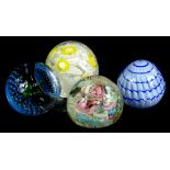 Four decorative glass paperweights, to include two with scrambled decoration in various colours.