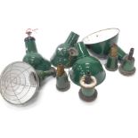 A collection of industrial ceiling lights, each with a dark green and white enamel shade, with