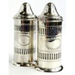 A pair of George V silver pepper pots, each with pierced decoration and with a vacant oval