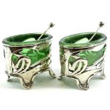 A pair of Edwardian silver salts, of Art Nouveau form, with pierced floral bodies on quadruple feet,