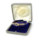 An Edwardian hinged bangle, set with central cluster of sapphire surrounded by seed pearls, with