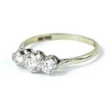 A platinum three stone diamond ring, set with three round brilliant cut diamonds, each in claw