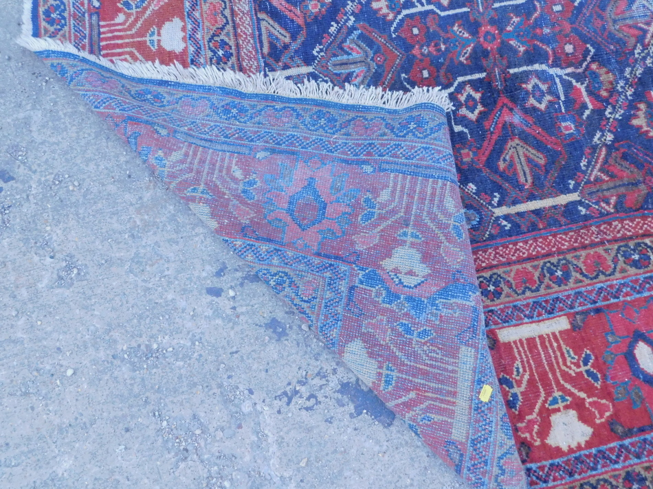 A Persian carpet, with an all over multi coloured design on a navy - Image 4 of 4